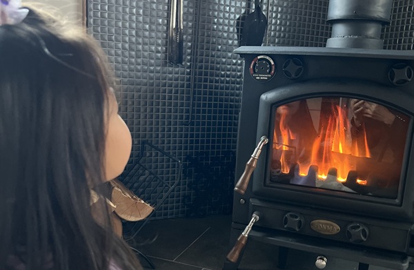 薪ストーブの炎を見る子供